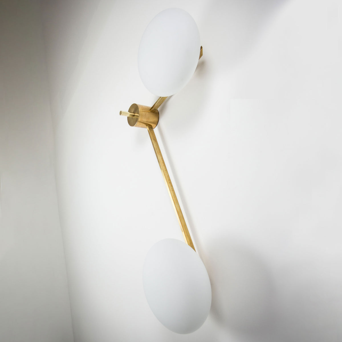 This elegant and iconic lamp in brass and opaline is inspired mid-century Italian design. 12:15 is composed of 2 arms that branch off from a central brass body, supporting with elegant lightness as many Murano opaline glass globes. It can be mounted both as a ceiling and a wall lamp. Angelo Lelli Style