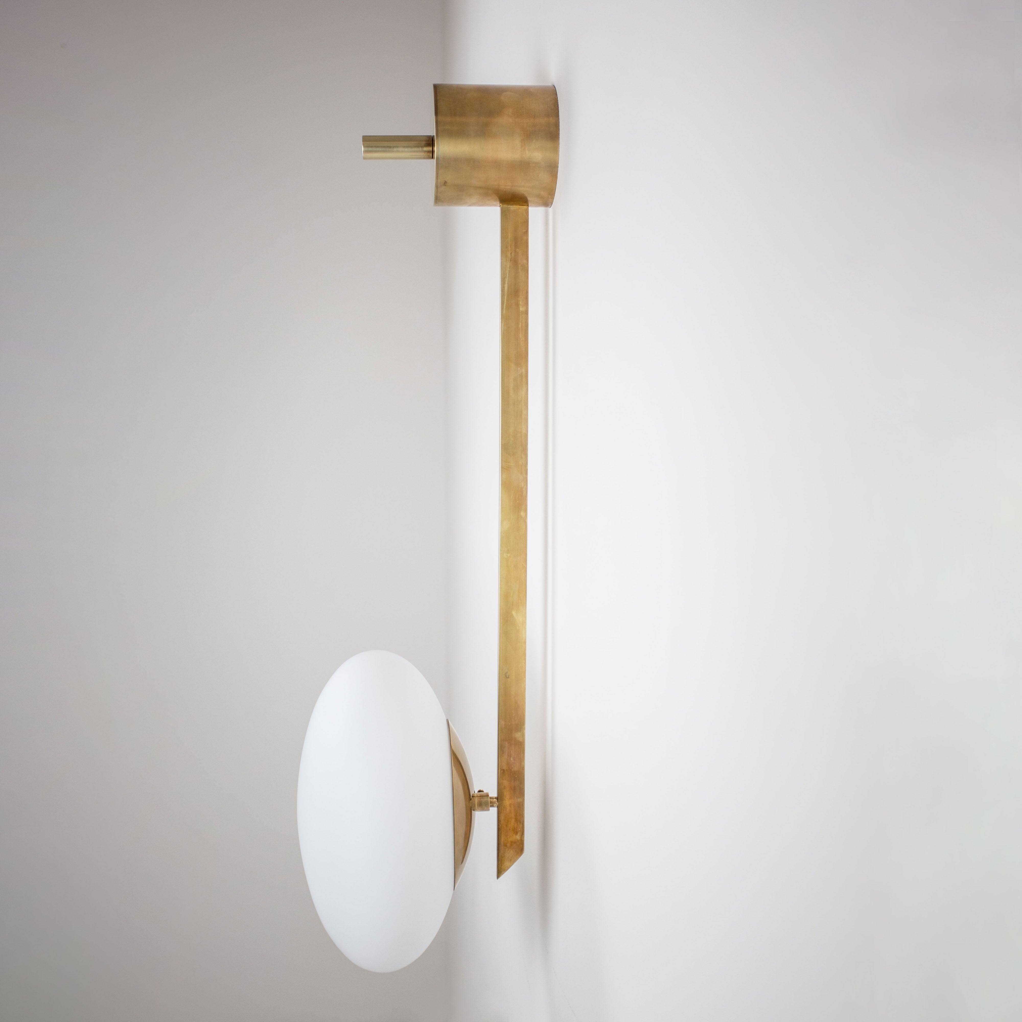 This elegant and iconic lamp in brass and opaline is inspired by mid-century Italian design. Angel is composed of an arm that supports with elegant lightness a Murano opaline glass globe. It can be mounted both as a ceiling and a wall lamp. Angelo Lelli Style