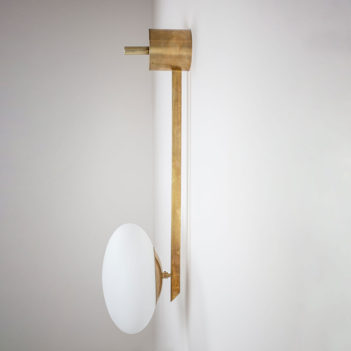 This elegant and iconic lamp in brass and opaline is inspired by mid-century Italian design. Angel is composed of an arm that supports with elegant lightness a Murano opaline glass globe. It can be mounted both as a ceiling and a wall lamp. Angelo Lelli Style