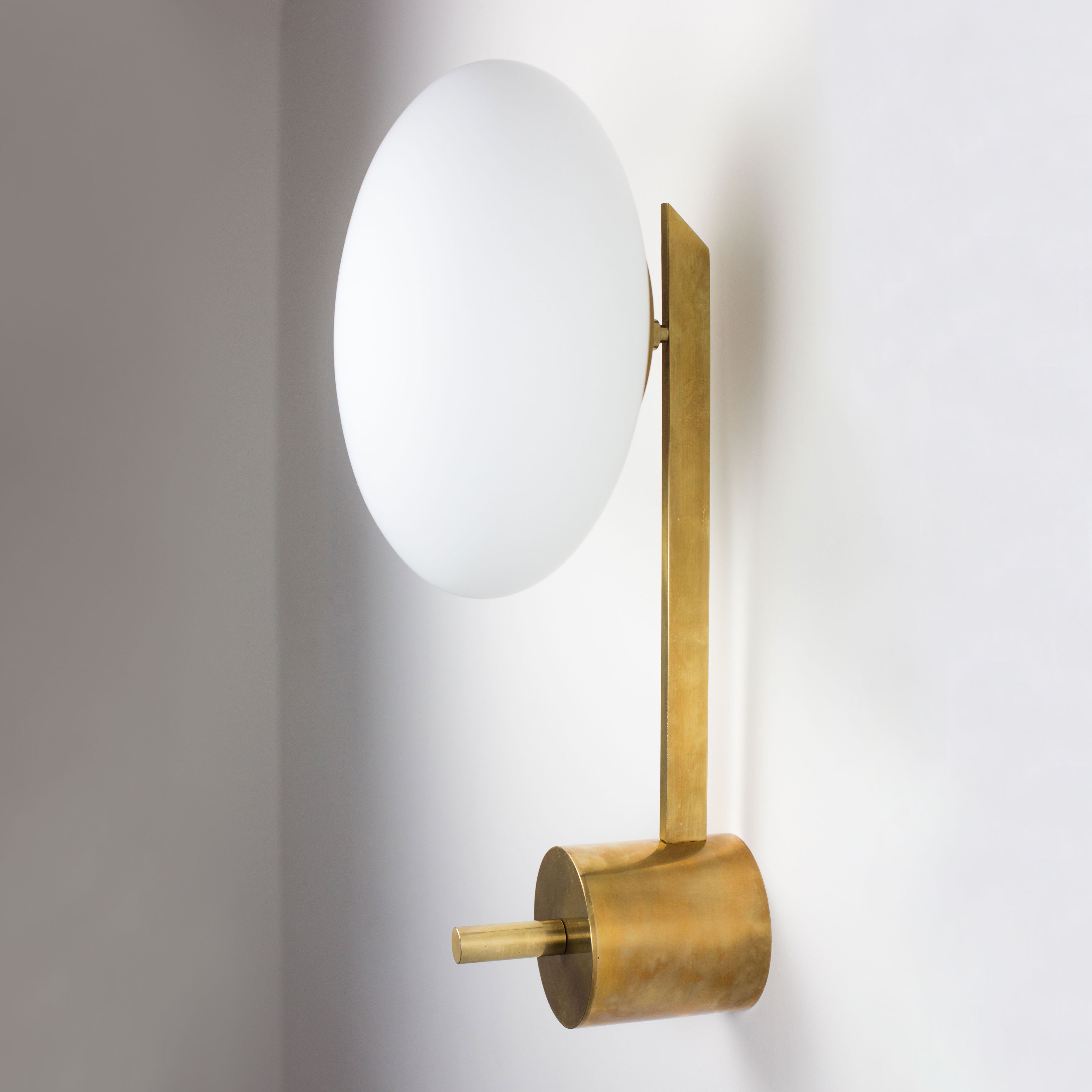 This elegant and iconic lamp in brass and opaline is inspired by mid-century Italian design. Baby is composed of an arm that supports with elegant lightness a Murano opaline glass globe. It can be mounted both as a ceiling and a wall lamp. Angelo Lelli Style