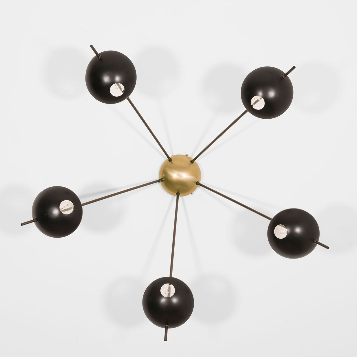 Penta, with its elements and its shapes simplicity and with its light and shadow effects, represents a tribute to sundials, ancient solar clocks. From a brass core, 5 thin arms branch off, lightly supporting 5 painted brass plates. Penta becomes a point of light and color in any home interiors, an element of creative and colored decoration.