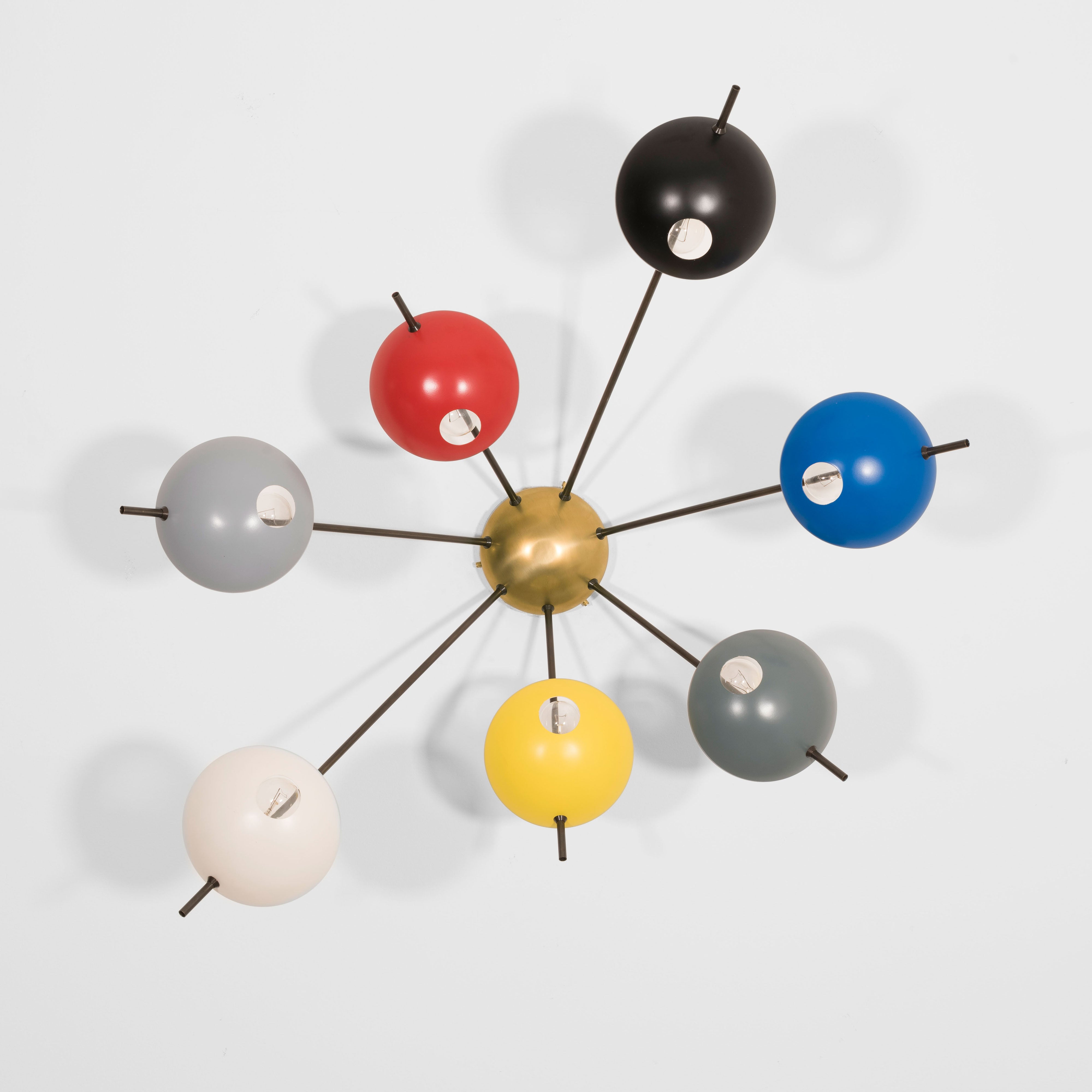 Septem I, with its elements and its shapes simplicity and with its light and shadow effects, represents a tribute to sundials, ancient solar clocks. From a brass core, 7 thin arms branch off, lightly supporting 7 painted brass plates. Septem I becomes a point of light and color in any home interiors, an element of creative and colored decoration.