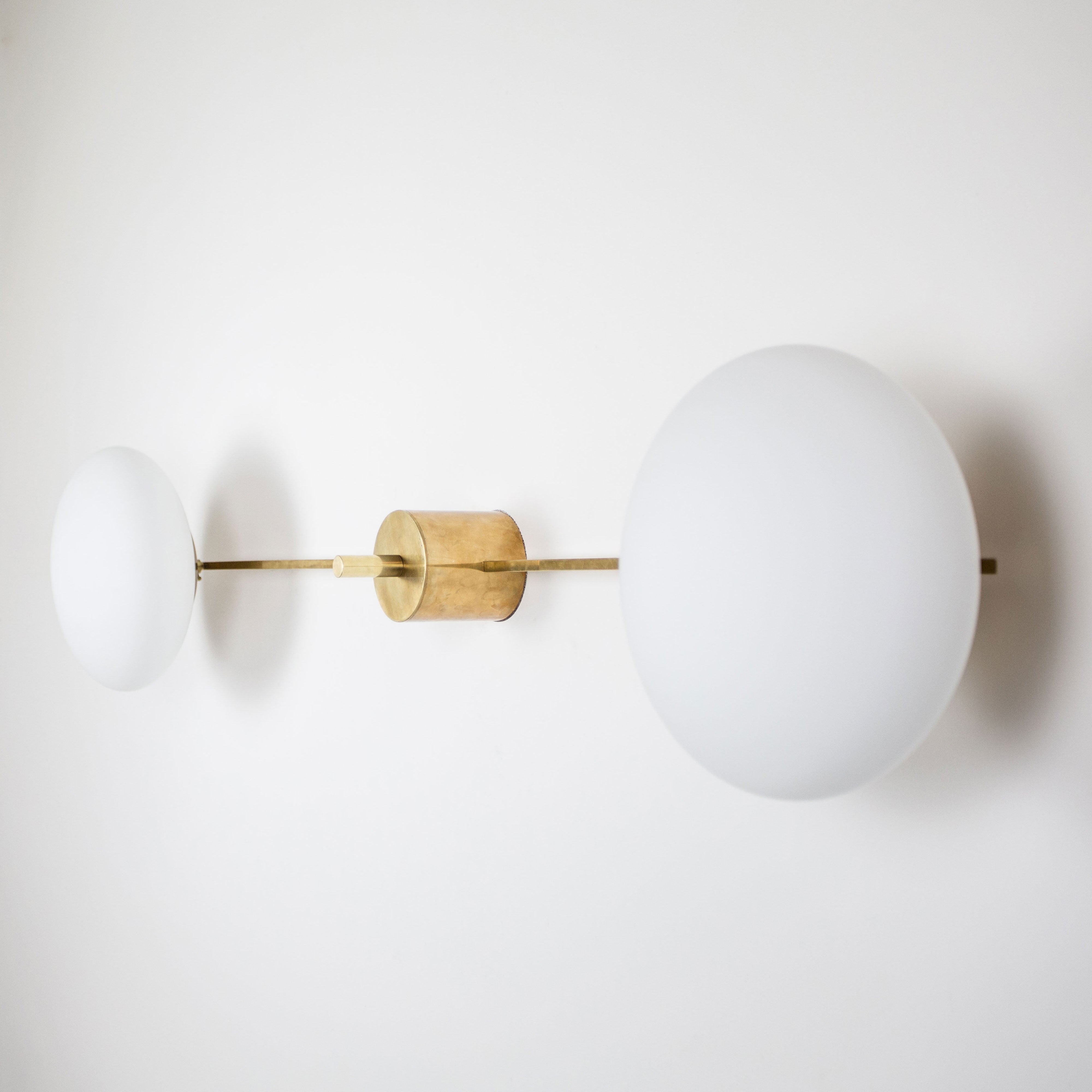 This elegant and iconic lamp in brass and opaline is inspired by mid-century Italian design. Snooker is composed of 2 arms that branch off from a central brass body, supporting with elegant lightness as many Murano opaline glass globes. It can be mounted both as a ceiling and a wall lamp. Angelo Lilli Style