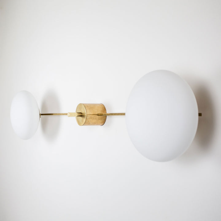 This elegant and iconic lamp in brass and opaline is inspired by mid-century Italian design. Snooker is composed of 2 arms that branch off from a central brass body, supporting with elegant lightness as many Murano opaline glass globes. It can be mounted both as a ceiling and a wall lamp. Angelo Lilli Style
