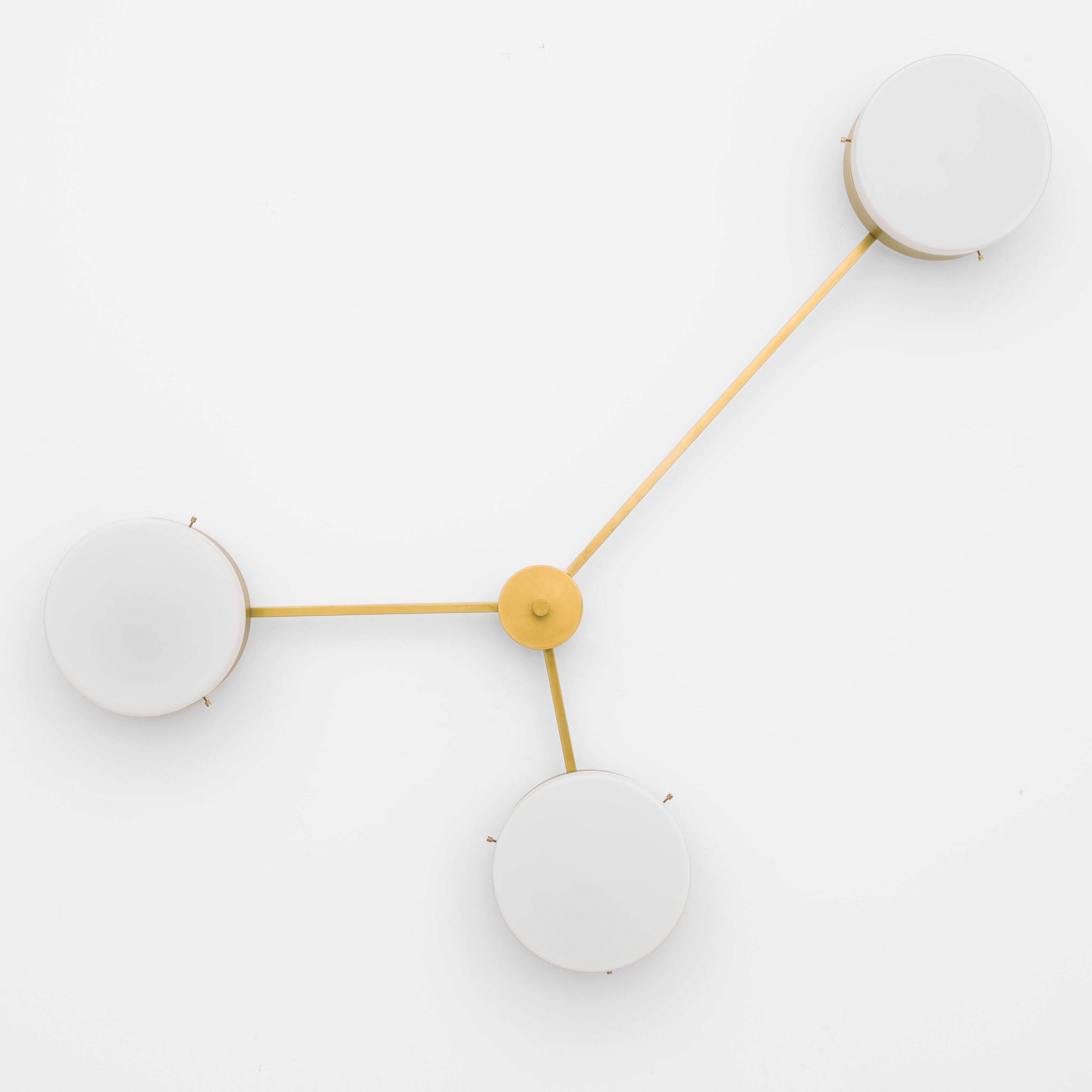 Syzygy, one of the pieces in the Celeste collection, is entirely handmade. The combination of minimalist shapes, captivating geometries and excellent materials creates the strong personality of this lamp. Thanks to its 3 opaline Murano glass globes supported by 3 brass arms, it stands out in the interior environment it is placed in. Syzygy can be mounted both as a hanging and a wall lamp.