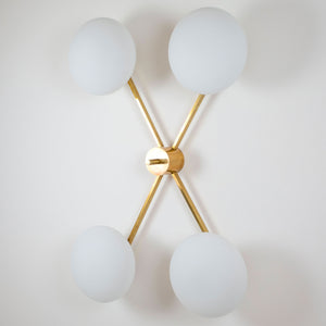 This elegant and iconic lamp in brass and opaline is inspired by mid-century Italian design. Butterfly is composed of 4 arms that branch off from a central brass body, supporting with elegant lightness as many Murano opaline glass globes. It can be mounted both as a ceiling and a wall lamp. Angelo Lelli Style
