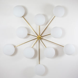 This elegant and iconic lamp in brass and opaline is inspired by mid-century Italian design. Cosmos is composed of 10 arms that branch off from a central brass body, supporting with elegant lightness as many Murano opaline glass globes. It can be mounted both as a ceiling and a wall lamp. Angelo Lelli Style