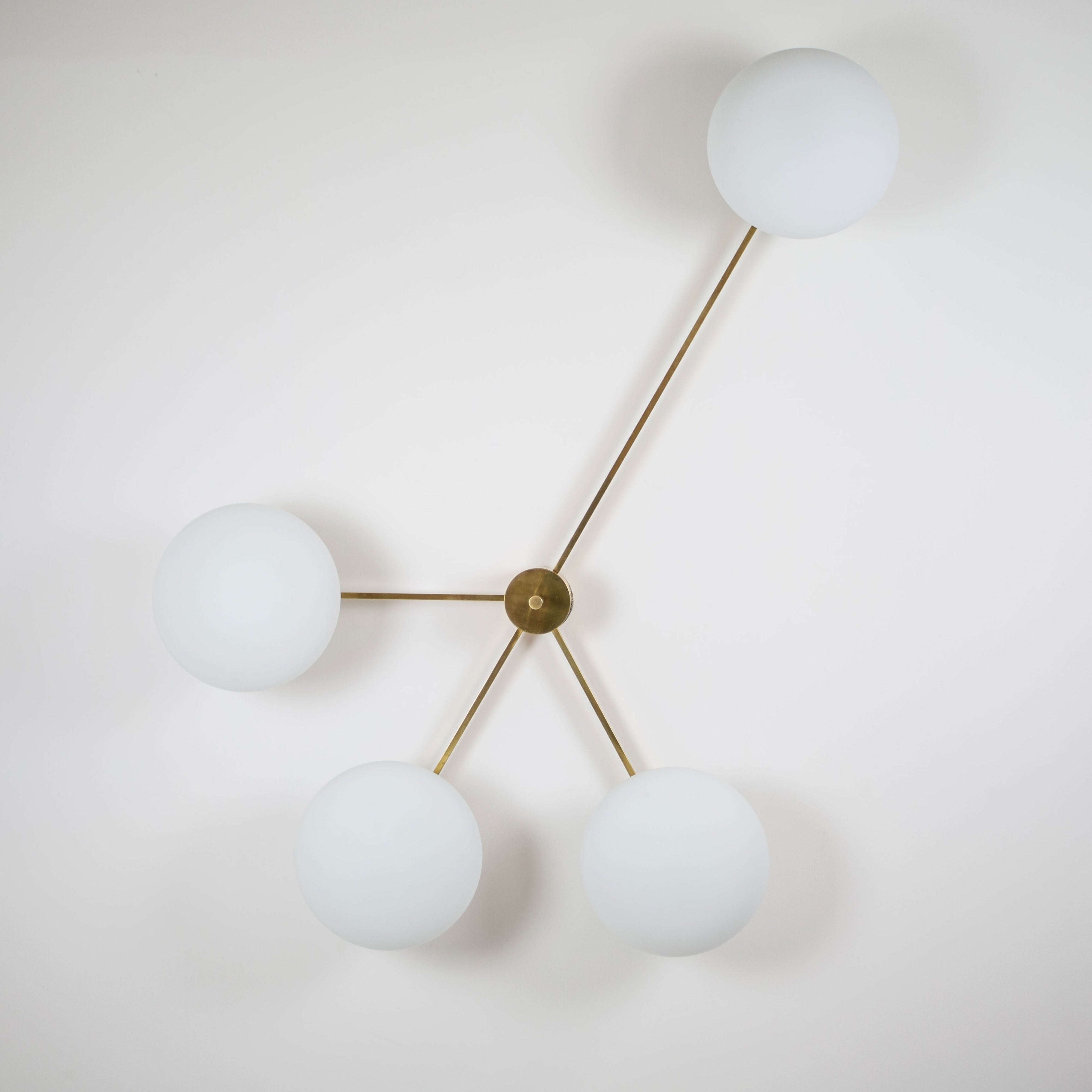  This elegant and iconic lamp in brass and opaline is inspired by mid-century Italian design. Love is composed of 4 arms that branch off from a central brass body, supporting with elegant lightness as many Murano opaline glass globes. It can be mounted both as a ceiling and a wall lamp. Angelo Lilli Style