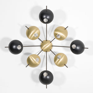 Octo I, with its elements and its shapes simplicity and with its light and shadow effects, represents a tribute to sundials, ancient solar clocks. From a brass core, 8 thin arms branch off, lightly supporting 8 painted brass plates. Octo I becomes a point of light and color in any home interiors, an element of creative and colored decoration