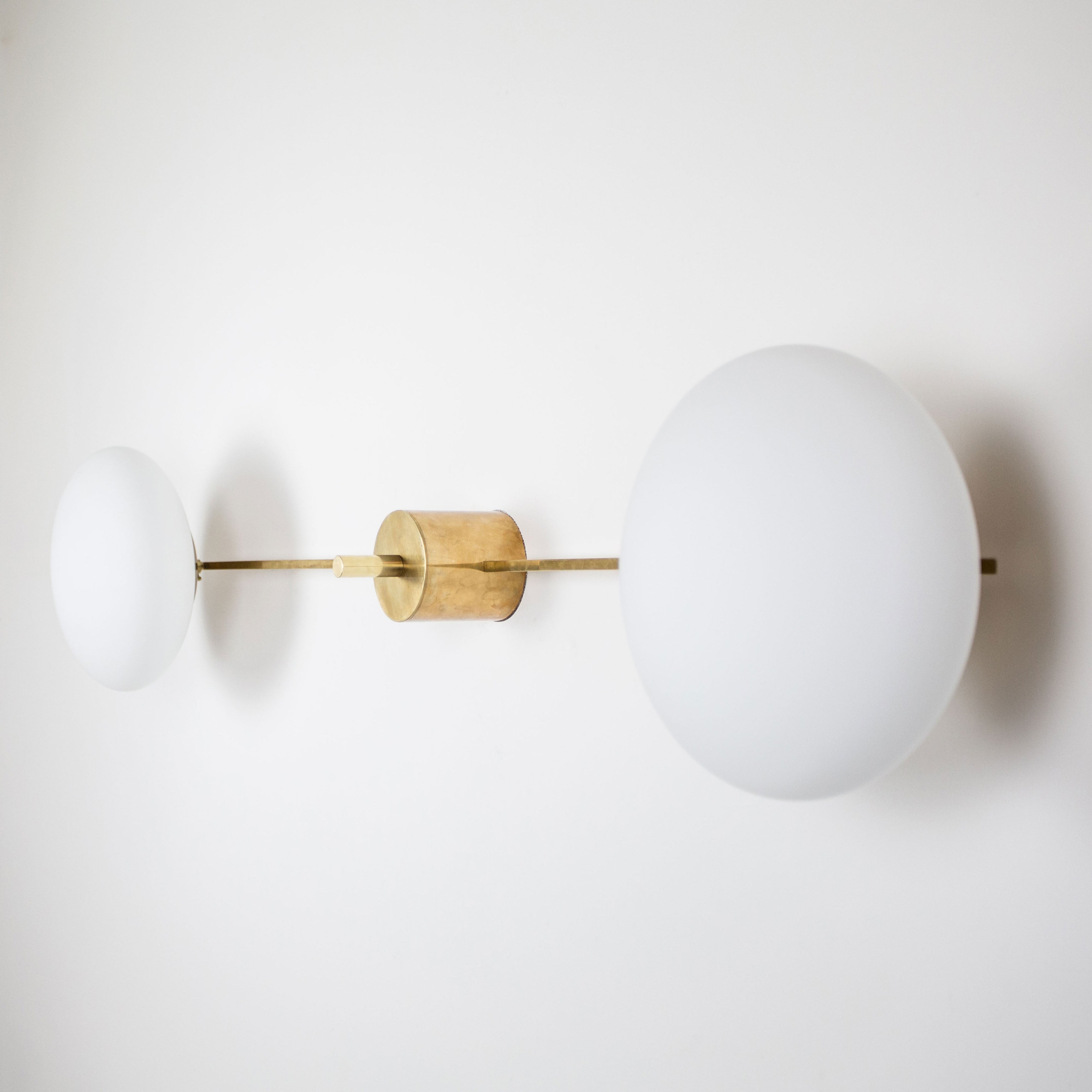  This elegant and iconic lamp in brass and opaline is inspired by mid-century Italian design. Snooker is composed of 2 arms that branch off from a central brass body, supporting with elegant lightness as many Murano opaline glass globes. It can be mounted both as a ceiling and a wall lamp. Angelo Lilli Style