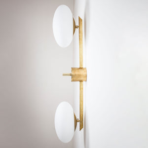  This elegant and iconic lamp in brass and opaline is inspired by mid-century Italian design. Toi&Moi is composed of 2 arms that branch off from a central brass body, supporting with elegant lightness as many Murano opaline glass globes. It can be mounted both as a ceiling and a wall lamp. Angelo Lelli style
